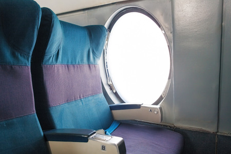 Old aircraft cabin seat near the windowの写真素材