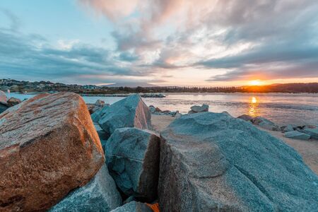 Sunset over shallow waters with huge boldersの写真素材