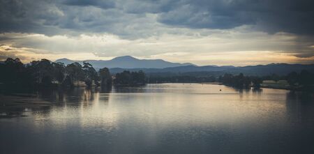 Landscape with shallow lake water and mountains at dusk. Image has analog lookの写真素材