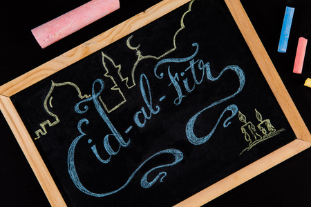 Eid al Fitr greeting hand written with colorful chalk on blackboard - closeupの写真素材