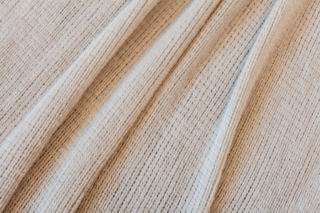 Soft beije fabric with folds background texture close-up
