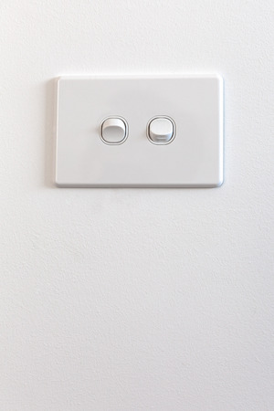 Modern double light switch on white wall with copy space - vertical image