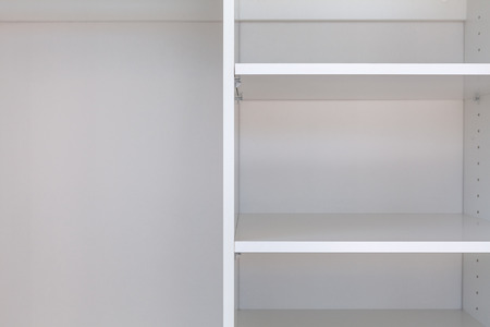 Close-up of empty shelves in white cupboardの写真素材