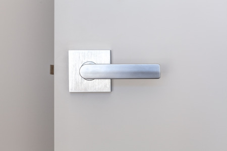 Close-up of metal door handle on white open doorの写真素材