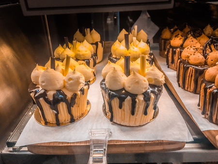 Rows of delicious cupcakes displayed in cafe storefront window