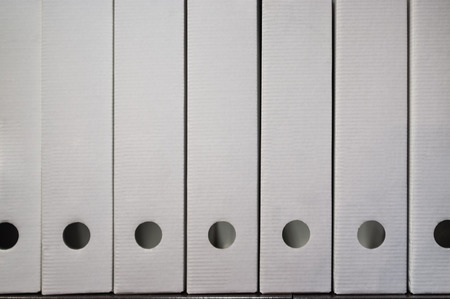 White document archive folders stacked on a shelf with copy space