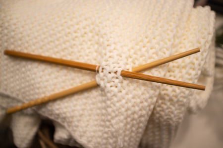 Soft homemade knitted wool with wooden needles closeupの写真素材