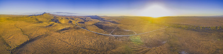 Large aerial panorama of vivid sunset over rural highway passing through desert landscape in South Australiaの写真素材