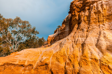 Majestic sandstone cliff glowing in sunset light over Murray River in Riverland, South Australiaの写真素材