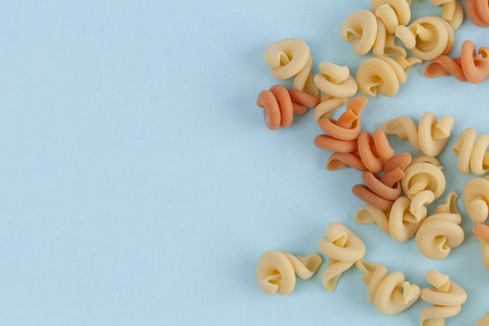 Funghetto pasta noodles on blue background with copy space