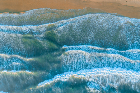 Ocean waves pound on the shore - aerial view