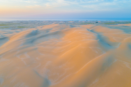 Pristine sand dunes glowing in orange sunrise - aerial view. Anna Bay, New South Wales, Australiaの写真素材