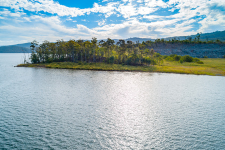 Lake and trees with white clouds and blue skies - scenic aerial landscapeの写真素材