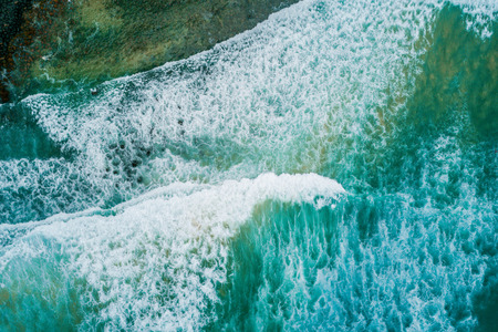 Aerial view - looking down at crushing ocean waves and white foamの写真素材