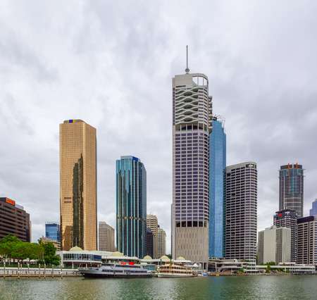 Skyscrapers and moored cruise boats on Brisbane river in Queensland, Australiaの写真素材