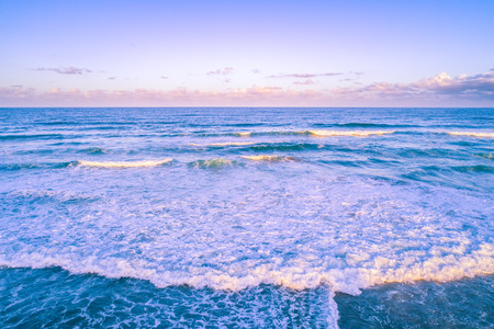 Beautiful ocean waves and clear sky at sunrise with copy spaceの写真素材