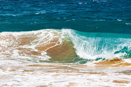 Crushing ocean wave lifting sand from the bottomの写真素材