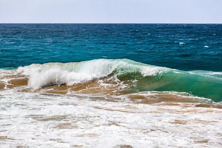 Crushing ocean wave with sand from the bottom and copy spaceの写真素材