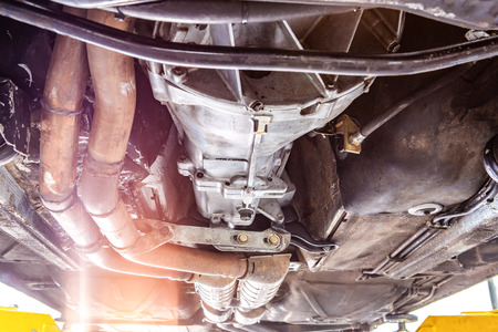 Closeup view of vehicle undercarriage on a lift in workshop during repairsの写真素材