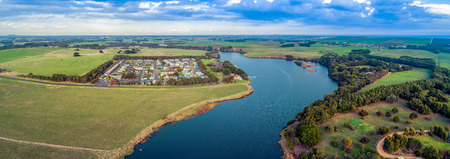 Aerial panorama of Hopkins River and holiday park surrounded by grasslandsの写真素材