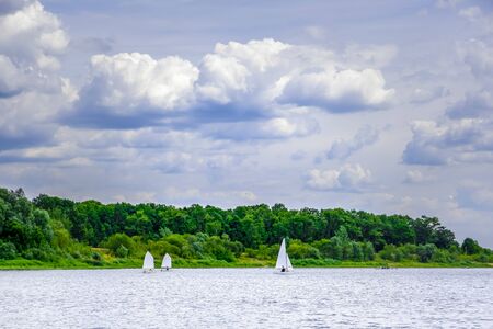 White sailboats sailing across the river Sozh in Gomel, Belarusの写真素材