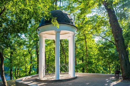 Gazebo with white columns among trees in the city park of Gomel, Belarusの写真素材