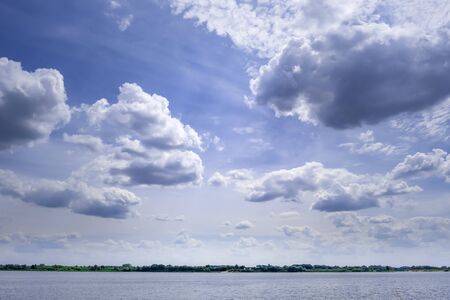 Minimalist landscape of small patch of water under vast beautiful sky with cloudsの写真素材