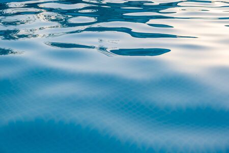 Gentle ripples on blue water in the pool background overlay