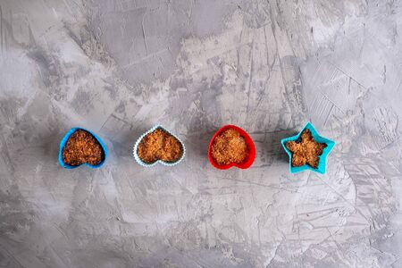 Cupcakes in colorful silicone forms on grungy concrete background - top view with copy spaceの写真素材