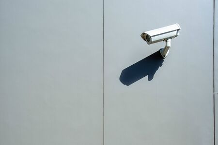 Surveillance wall mounted outdoor camera with harsh daylight shadow and copy spaceの写真素材