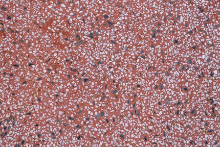 Stone chips in red cement abstract background with copy space