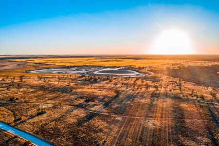 Bright sun flare over Australian desert at sunset - aerial viewwの写真素材