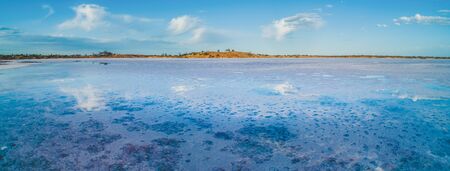 Wide panorama of clouds reflecting in salt lakeの写真素材