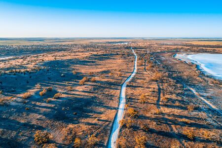 Road passing through Australian outback at sunriseの写真素材