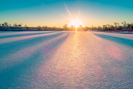 Sunset with sun flare over salt lake in the desertの写真素材