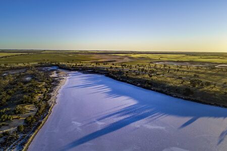 Sunset casting long tree shadows on salt Lake Hardy. Murray-Sunset National Park, Victoria, Australiaの写真素材