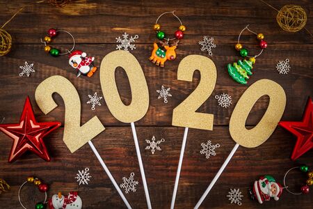 2020 numbers with golden glitter and Christmas decorations on wooden background - top viewの写真素材