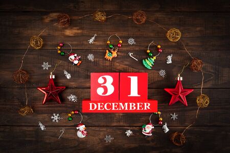 December 31st - concept date with red cubes and Christmas decorations arranged on beautiful rustic wooden backdrop - top viewの写真素材
