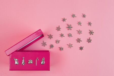 Burst of snowflakes escaping from open gift box on pink background. Christmas theme conceptの写真素材