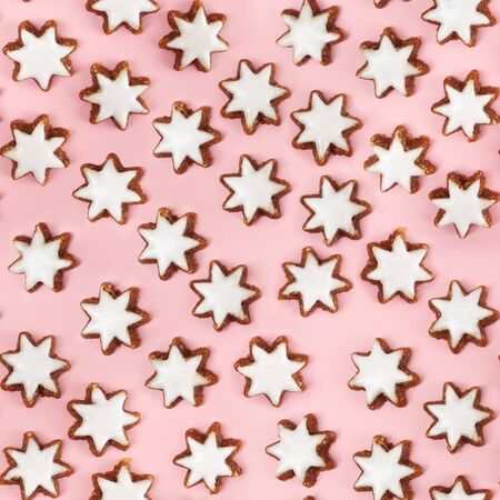Almond stars biscuits with sugar icing on pink background - seamless patternの写真素材