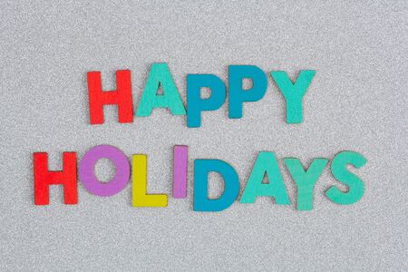 Colorful Happy Holidays text arranged with letters on silver glitterの写真素材