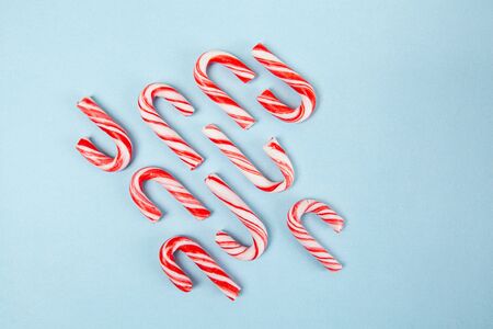 Candy canes on blue background - top view with copy spaceの写真素材
