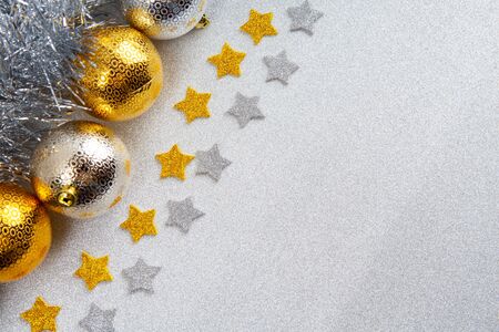Christmas theme background with baubles, stars and tinsel on glitter with diagonal text spaceの写真素材