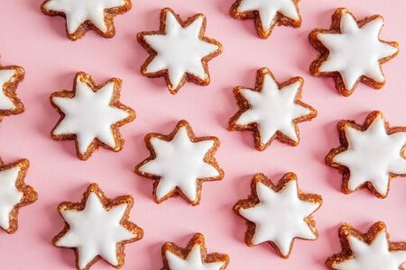Hazelnut stars with icing pattern on pink background - top viewの写真素材