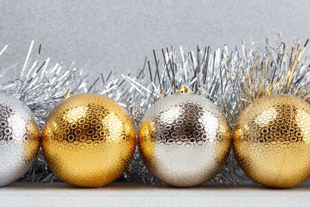 Row of Christmas baubles with silver tinsel on glittery background - closeupの写真素材