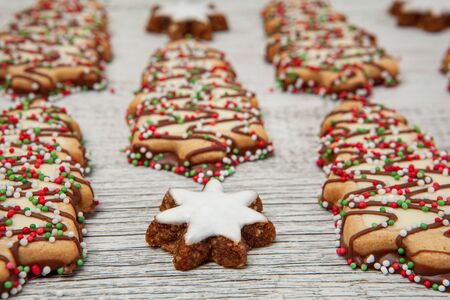 Christmas tree biscuits and almond stars dessert on white wood in perspective with shallow focusの写真素材