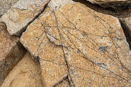 Large granite boulder crossed with many cracks background texture overlay