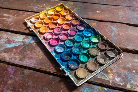 Large used colorful watercolor palette on wooden tableの写真素材