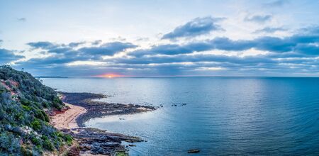 Sunset over ocean near the coastline - aerial panoramaの写真素材