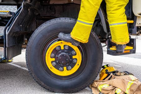 Fireman feet climbing into the fire engine cabinの写真素材